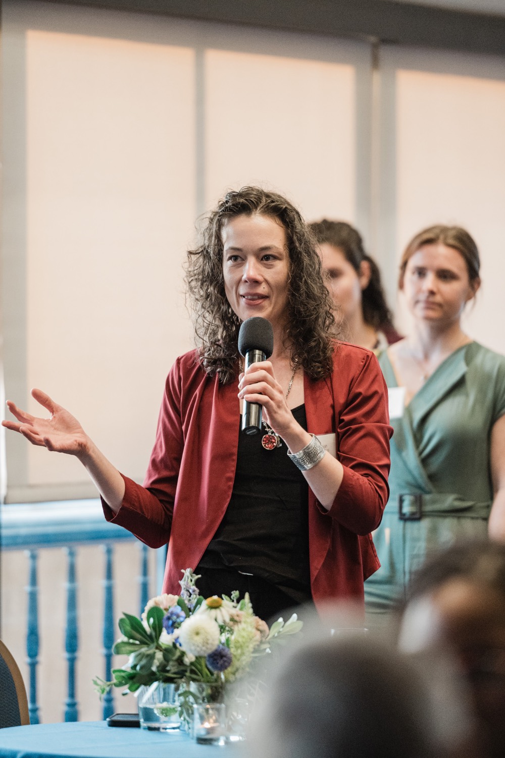 Woman speaking to crowd holding a microphone